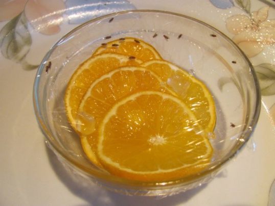 Нарезать ломтиками цитрусовый фрукт и накрыть его пленкой с мелкими отверстиями